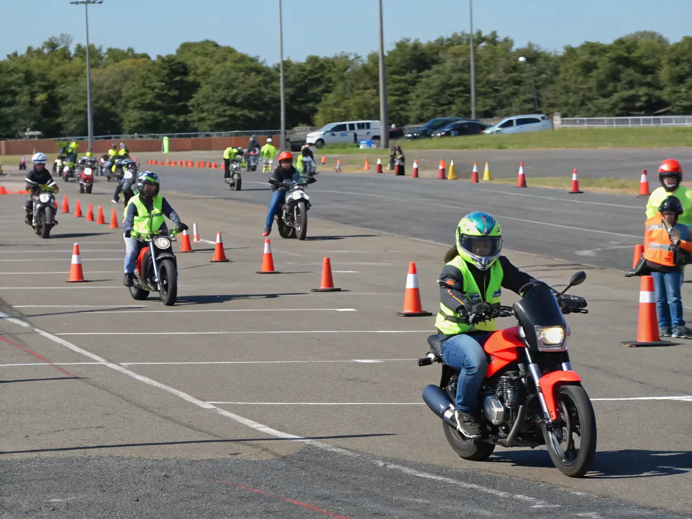 A professional instructor demonstrating advanced riding techniques to a group of attentive motorcyclists during a BMP BALADES MOTOS PASSION workshop.